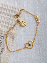 Cinta Gold bracelet by Leeloobird Bali with a heart-shaped charm on a textured white background