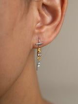 Close-up of an ear wearing aSky earring model in Sterling silver 925 with a clear gemstone on a neutral background