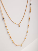 The meaningful and spiritual Favorite necklace handmade by Leeloobird Jewelry in Bali with two layered gold necklaces with small beads on a light gray background