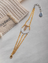 Meaningful Gold Vermeil and sterling silver Energy bracelet handmade by Leeloobird Jewlery baliwith a moon design on a light gray surface