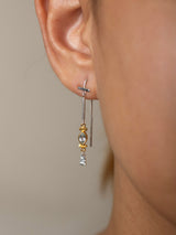 Close-up of an ear wearing aSky earring model in Sterling silver 925 with a clear gemstone on a neutral background